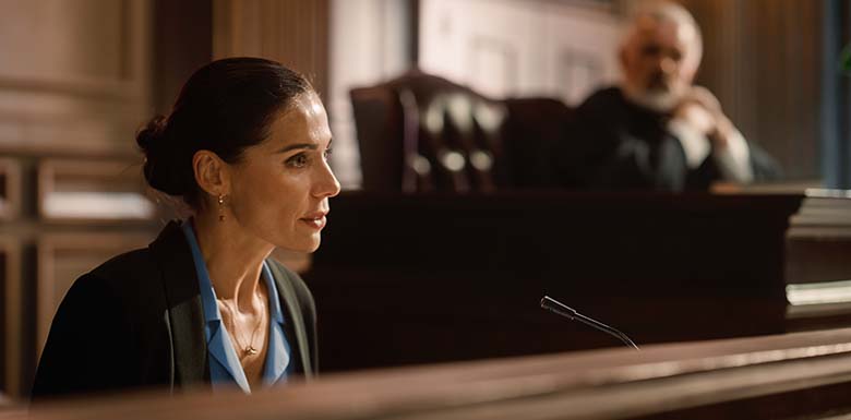 Woman in suit giving testimony in court room